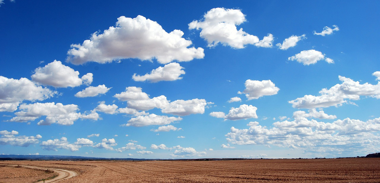 A photo of clouds against a blue sky. The clouds have shades of gray that provide depth.